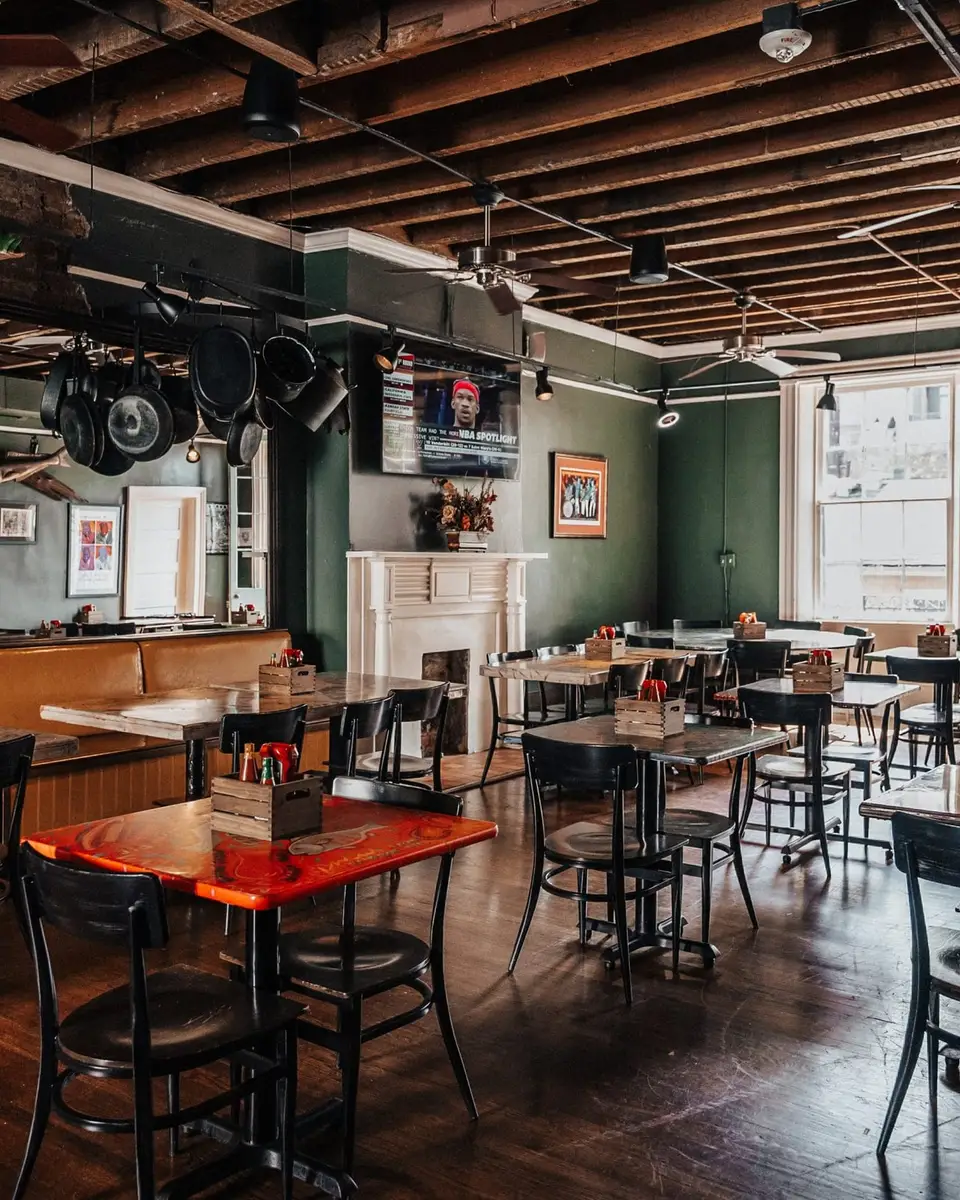 The Mardi Gras Room: charcoal walls, booths and tables under exposed beams