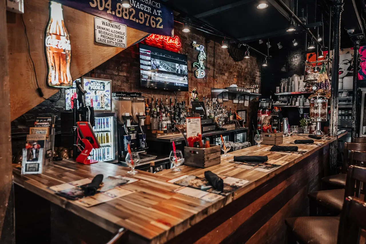 Main Dining Room bar with stools, neon signs and televisions