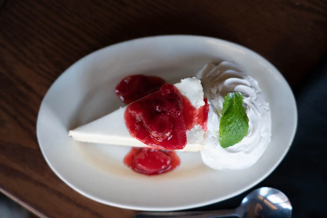 Slice of New York-style strawberry cheesecake with whipped cream